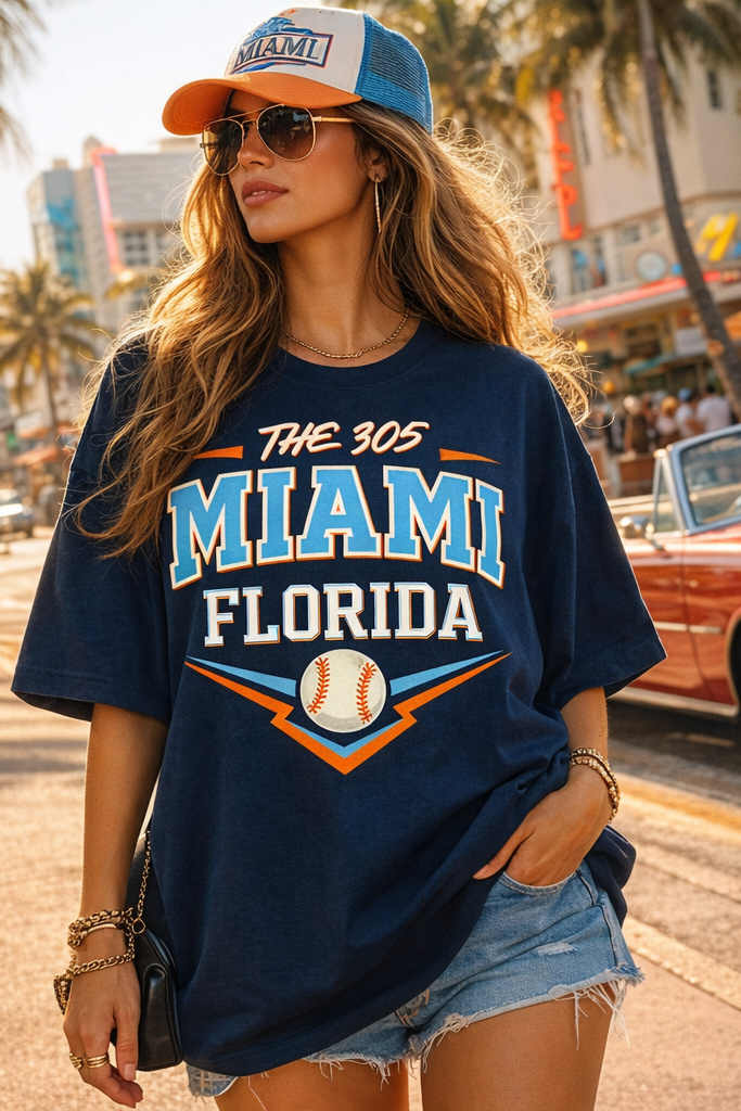Woman wearing a 'The 305 Miami Florida' t-shirt and cap on a city street.