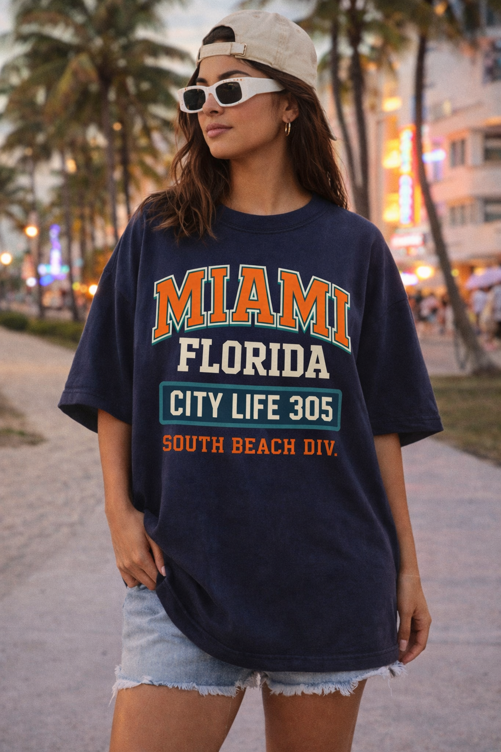 Person wearing a navy blue t-shirt with 'Miami Florida' text, standing on a beach boardwalk.