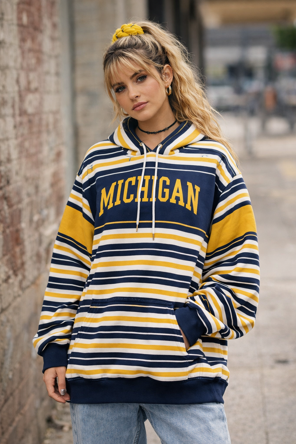 Person wearing a striped hoodie with 'Michigan' text outdoors.