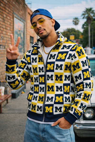 Man wearing a patterned hoodie with 'M' logo, standing outdoors.