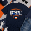 Navy blue t-shirt with 'New York Baseball Athletic' text, surrounded by a cap, sunglasses, and jeans on a colorful background.