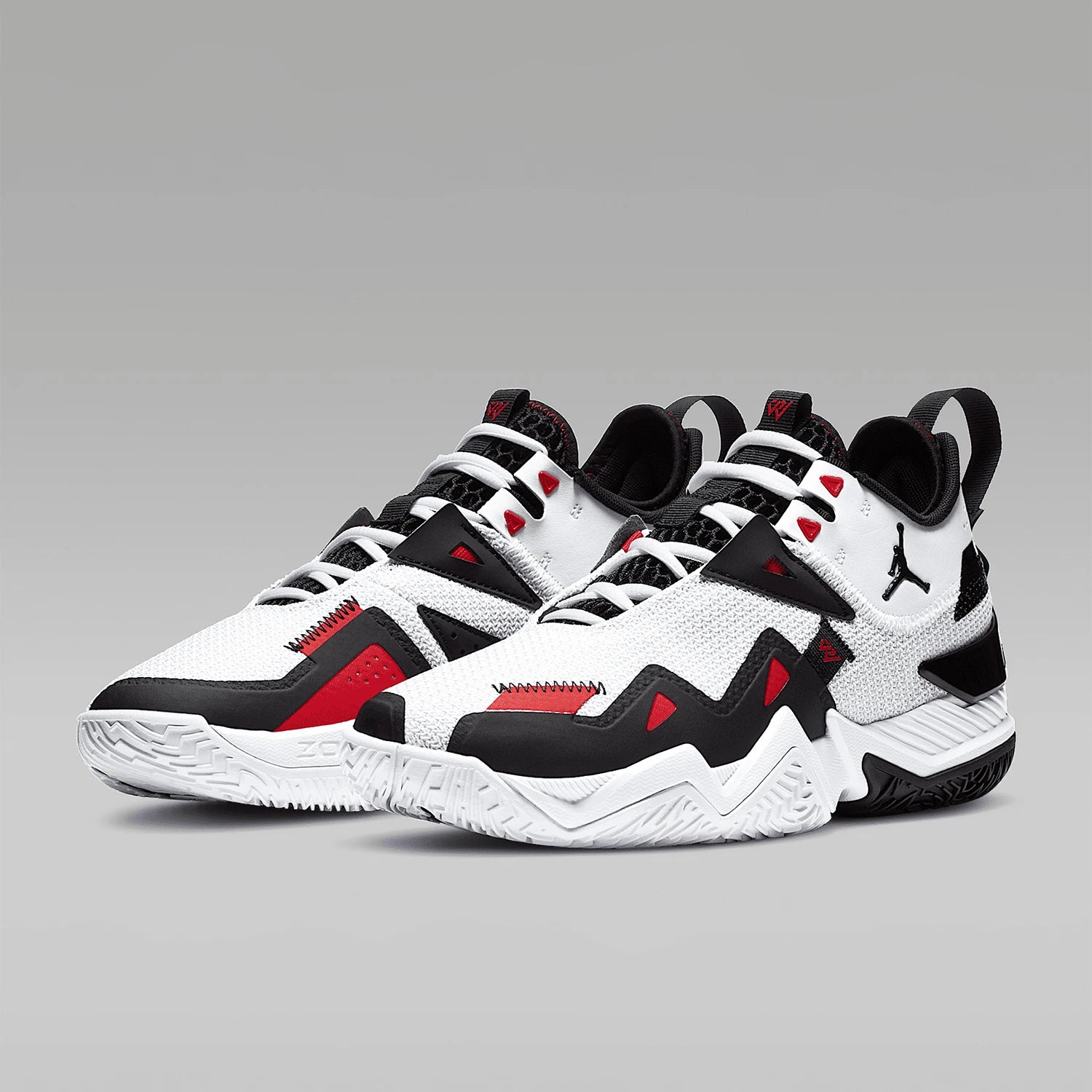 White, black, and red sneakers on a gray background