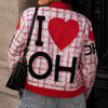 Person wearing a plaid jacket with 'I ❤️ OH' text and red heart design.