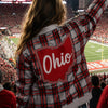 Person wearing a plaid jacket with 'Ohio' on it at a sports event.