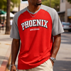 Man wearing a red and gray 'Phoenix Arizona' shirt on a city street.