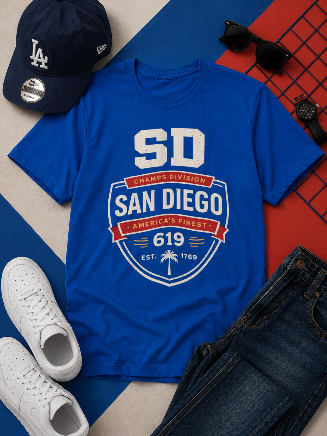 Blue t-shirt with 'San Diego' design, LA Dodgers cap, sunglasses, and white sneakers on a colorful background.