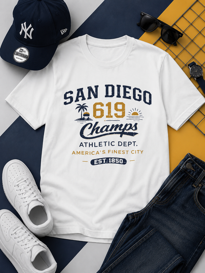 White t-shirt with 'San Diego 619 Champs' design, surrounded by a cap, sunglasses, shoes, and jeans on a multicolored background.