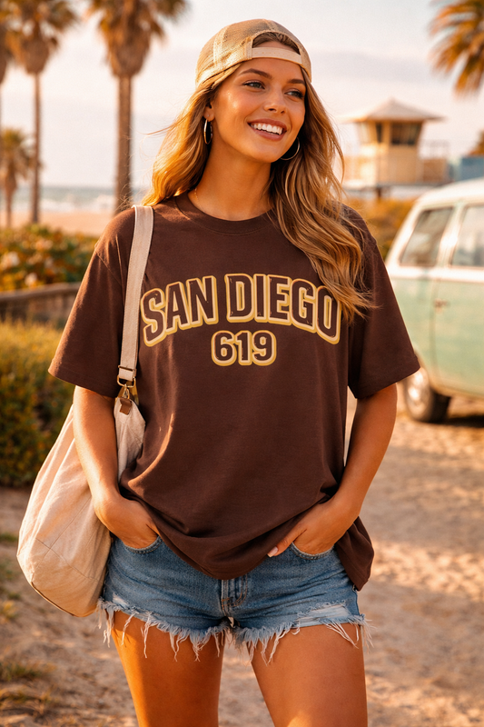 Woman wearing a 'San Diego 619' t-shirt with a vintage car and palm trees in the background.