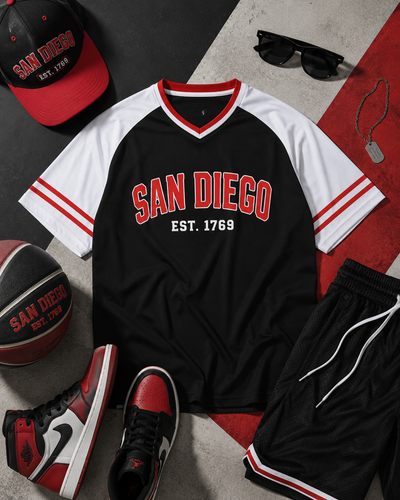Black and white sports jersey with 'San Diego' text, surrounded by accessories on a patterned surface.