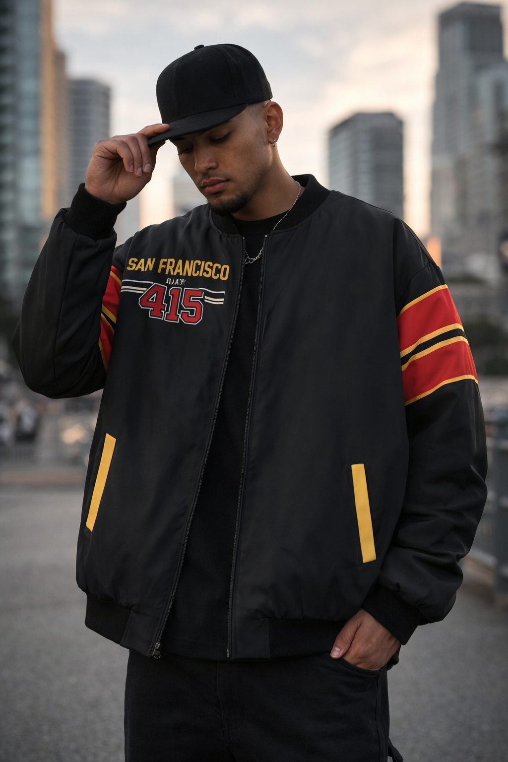 Man wearing a black jacket with red and yellow accents, standing in an urban setting.