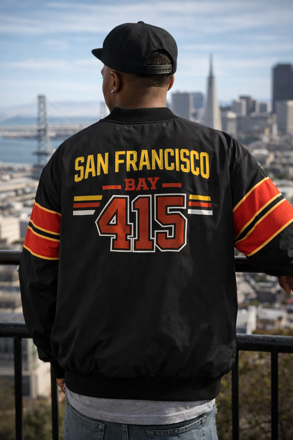 Person wearing a black jacket with 'San Francisco Bay 415' text, standing against a cityscape.