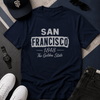 Navy t-shirt with 'San Francisco 1848 The Golden State' text, surrounded by a cap, sunglasses, watch, and shoes on a patterned surface.