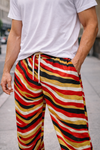 Person wearing colorful striped pants with a blurred urban background