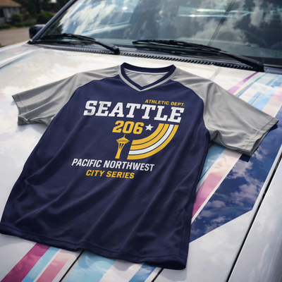 Navy and gray sports jersey with 'Seattle 206' and 'Pacific Northwest City Series' text on a car hood.