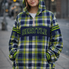 Person wearing a plaid hoodie with 'Seattle' text on a city street