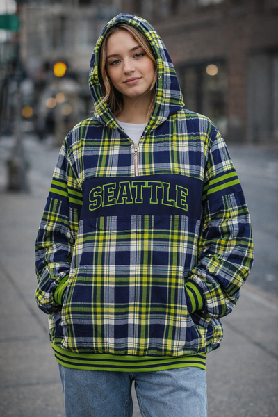 Person wearing a plaid hoodie with 'Seattle' text on a city street