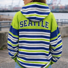 Person wearing a striped hoodie with 'Seattle' on the back, standing outdoors.
