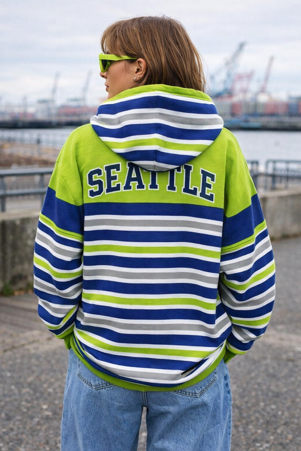 Person wearing a striped hoodie with 'Seattle' on the back, standing outdoors.