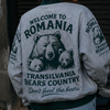 Person wearing a jacket with bear graphics and text, standing next to a motorcycle.
