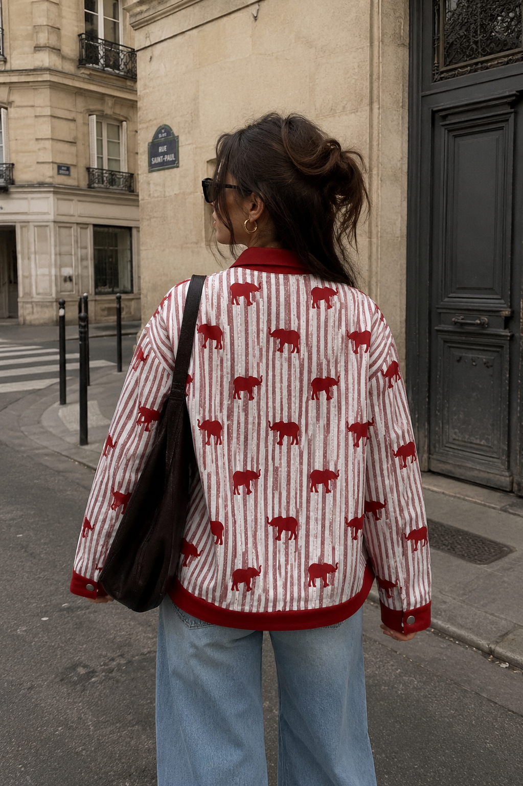 Person wearing a red and white patterned shirt on a city street.