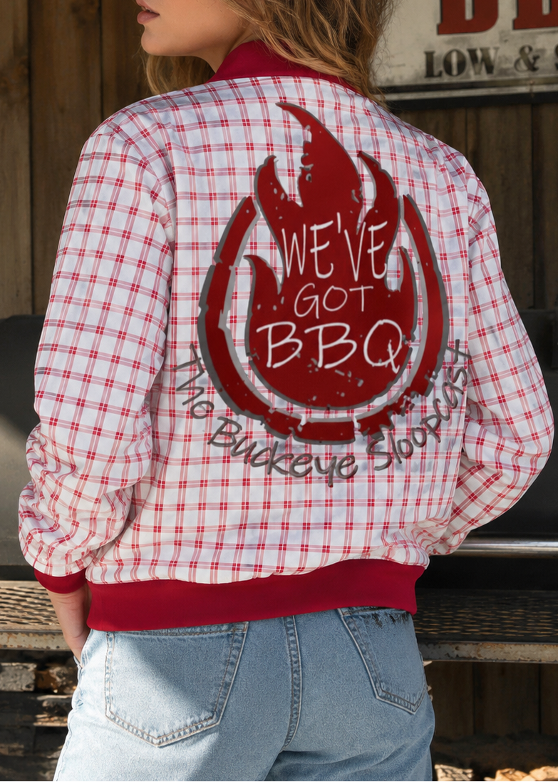 Person wearing a red and white checkered jacket with 'We've Got BBQ' text, standing in front of a 'Texas Style BBQ Low & Slow' sign.