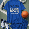 Blue t-shirt with 'Chicago Champs 85 State College' text, shorts, sneakers, basketball, and headphones on a sports court.